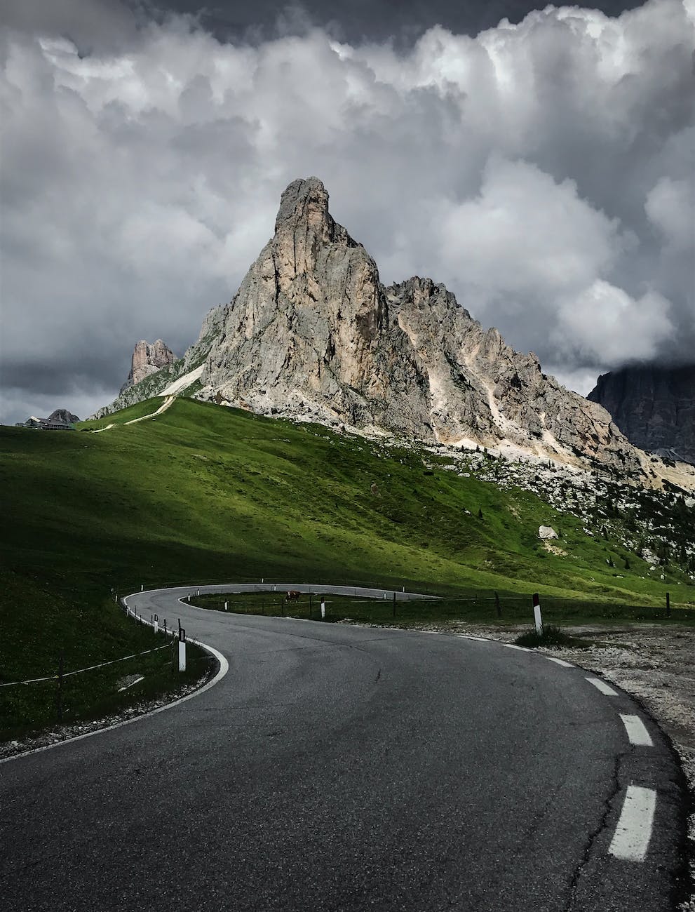 mountain near green grass field and asphalt road